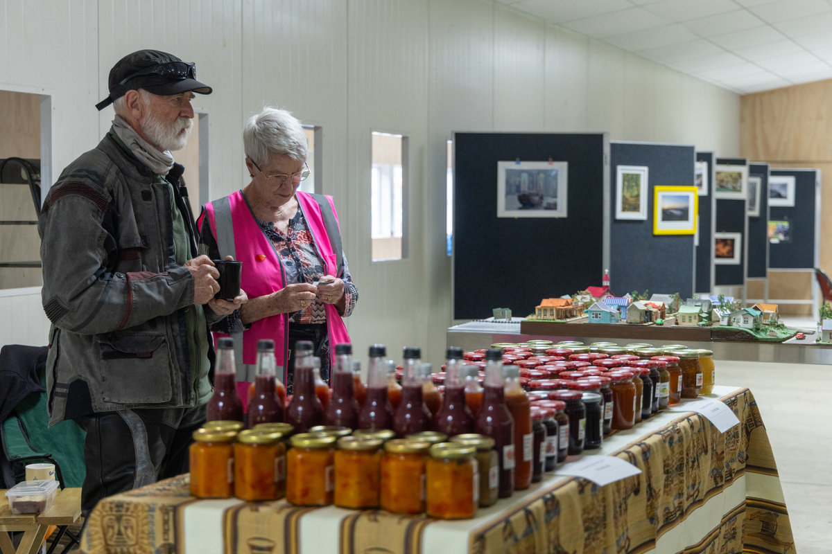 Produce stall in the pavillion with art society photo display in background